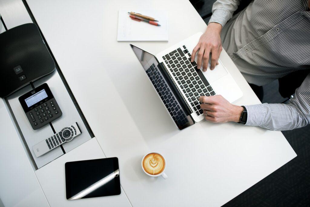 Person Using Laptop On White Wooden Table